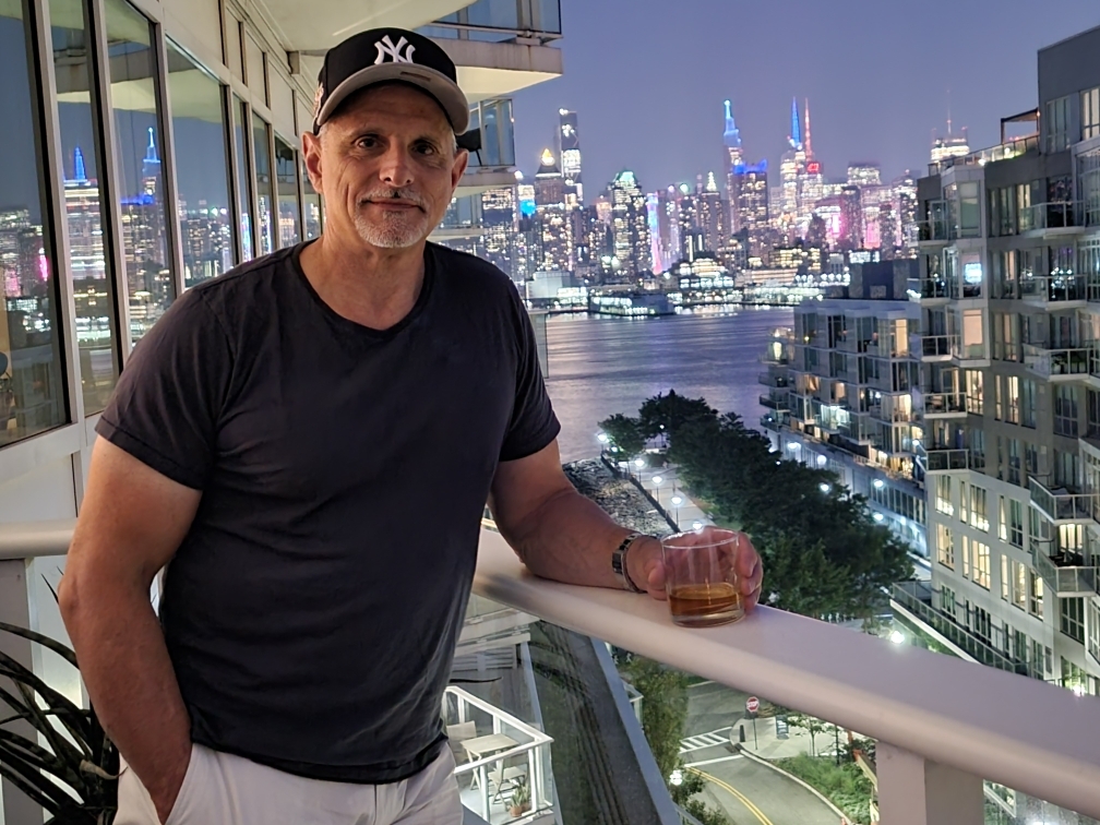 man on balcony sipping scotch 